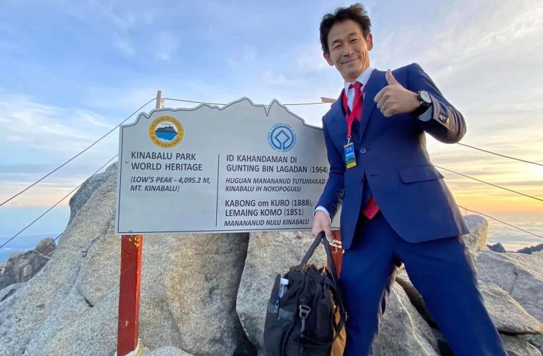 Japanese Bussinessman wearing a full office suit climbed Mount Kinabalu