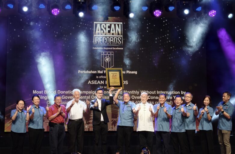 Group of people on a stage holding a framed award during an ASEAN Records event ceremony.