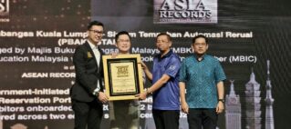 Four men on stage hold a framed award plaque as others look on, with an ASEAN Records backdrop behind them.