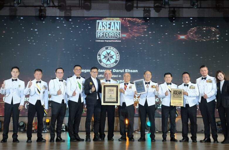 Group of men and women in white uniforms on stage, holding certificates and posing for a photo at an awards event with ASEAN Records backdrop.