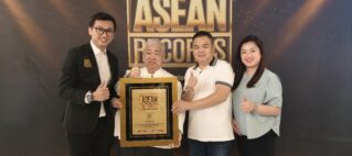 Four people posing with a gold-framed ASEAN Records plaque at an awards event, giving thumbs up.