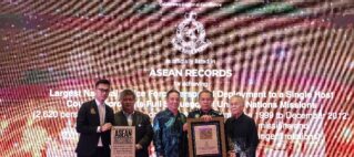 Group of men in formal attire posing on stage at an ASEAN Records awards ceremony, holding framed certificates in front of a celebratory backdrop with fireworks and text.
