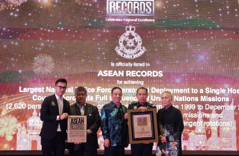 Group of men in formal attire posing on stage at an ASEAN Records awards ceremony, holding framed certificates in front of a celebratory backdrop with fireworks and text.