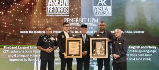Group of men in formal attire posing with framed awards on a stage at an ASEAN Records event, with glowing backdrop and logos in the background.