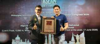 Two men on stage holding a framed award plaque with an ASEAN Records backdrop behind them. One wears a suit, the other a blue shirt, both giving a thumbs up to celebrate the award.