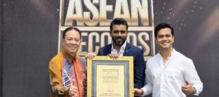 Three men pose with a large gold-framed certificate at an ASEAN Records event, smiling for the camera.