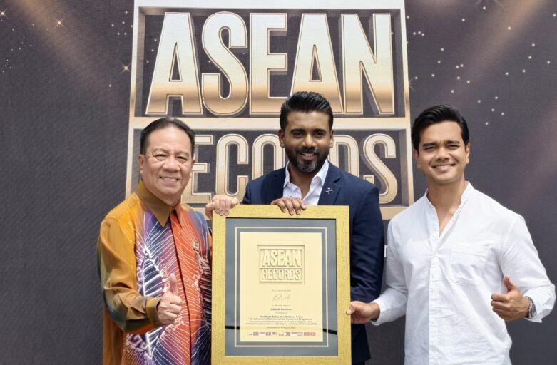 Three men pose with a large gold-framed certificate at an ASEAN Records event, smiling for the camera.