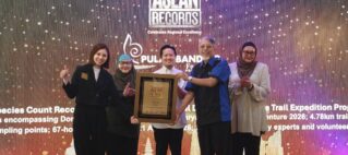 Group of five people on a stage posing with a framed award against a bright, dotted backdrop featuring ASEAN Records branding.