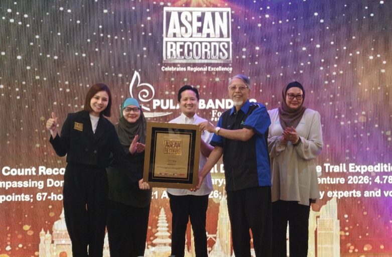 Group of five people on a stage posing with a framed award against a bright, dotted backdrop featuring ASEAN Records branding.